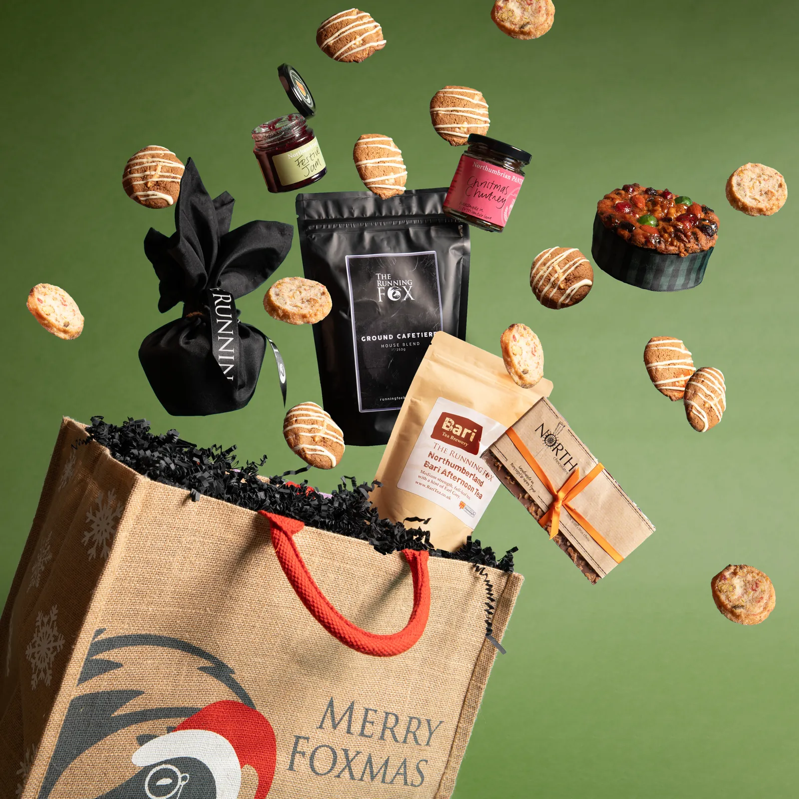 A Foxmas Tale gift bag with coffee, tea, jam, chutney, Christmas cake and cookies bursting out