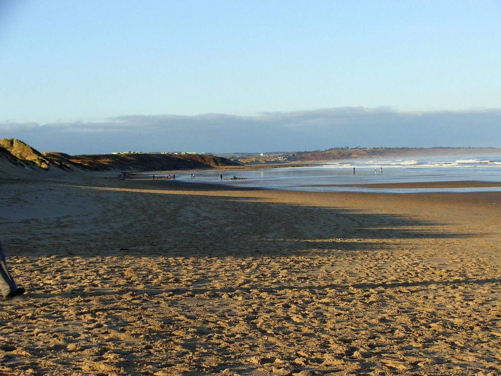 The wide, almost empty sands of Warkworth Beach stretching north under a clear sky