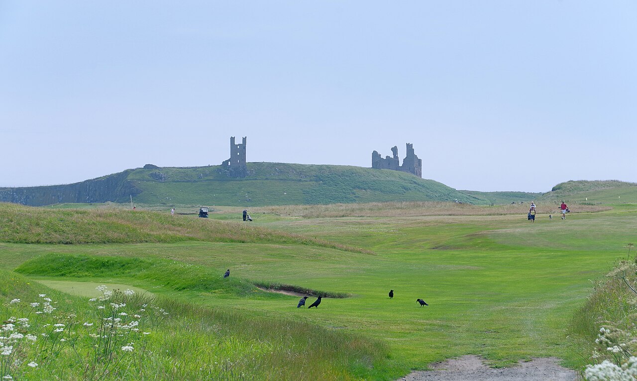 The ruins of Dunstanburgh Castle on the green headland near Craster